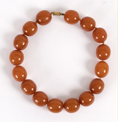 Lot 111 - An amber necklace of large slightly oval beads,...