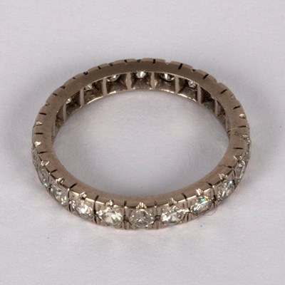 Lot 6 - A diamond eternity ring set in white precious...