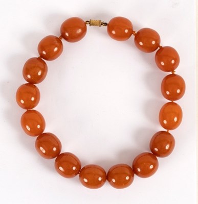 Lot 11 - An amber necklace of large slightly oval beads,...