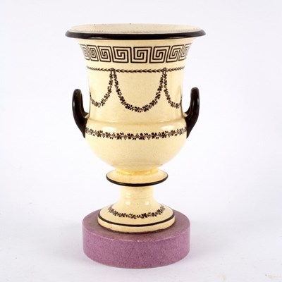 Lot 207 - A creamware two-handled vase on a pedestal...