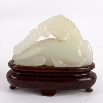 Lot 300 - A Chinese white jade carving of a recumbent...