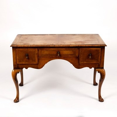 Lot 560 - A walnut kneehole dressing table, fitted three...