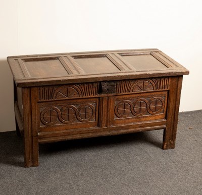 Lot 619 - A carved oak chest with triple-panel top,...