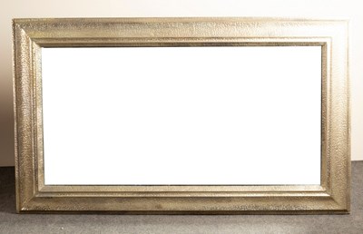 Lot 677 - A large modern mirror, the frame with dimpled...