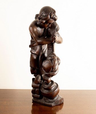 Lot 729 - A carved oak wooden figure of a boy by a...