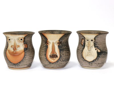 Lot 275 - Three studio pottery face mugs, 9cm high