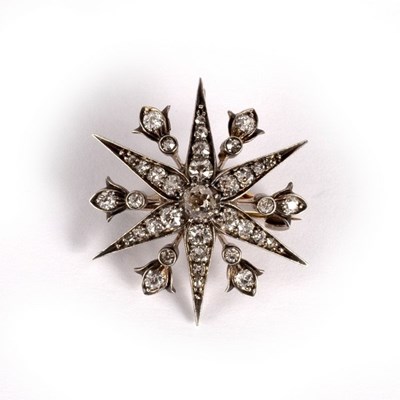 Lot 16 - A diamond starburst brooch/pendant, the pin...