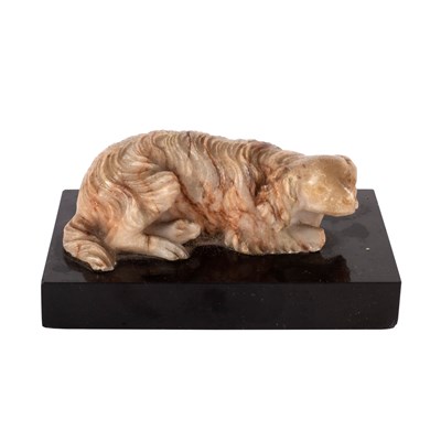 Lot 617 - A carved alabaster figure of a recumbent dog,...