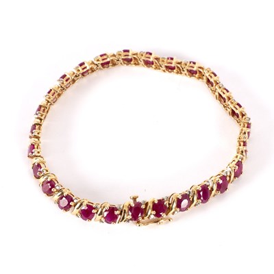 Lot 742 - A ruby and diamond bracelet, set in 14k yellow...