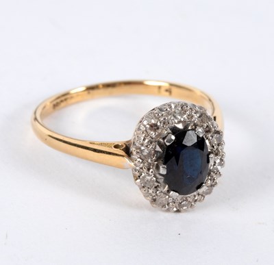 Lot 10 - A sapphire and diamond cluster ring, the oval...