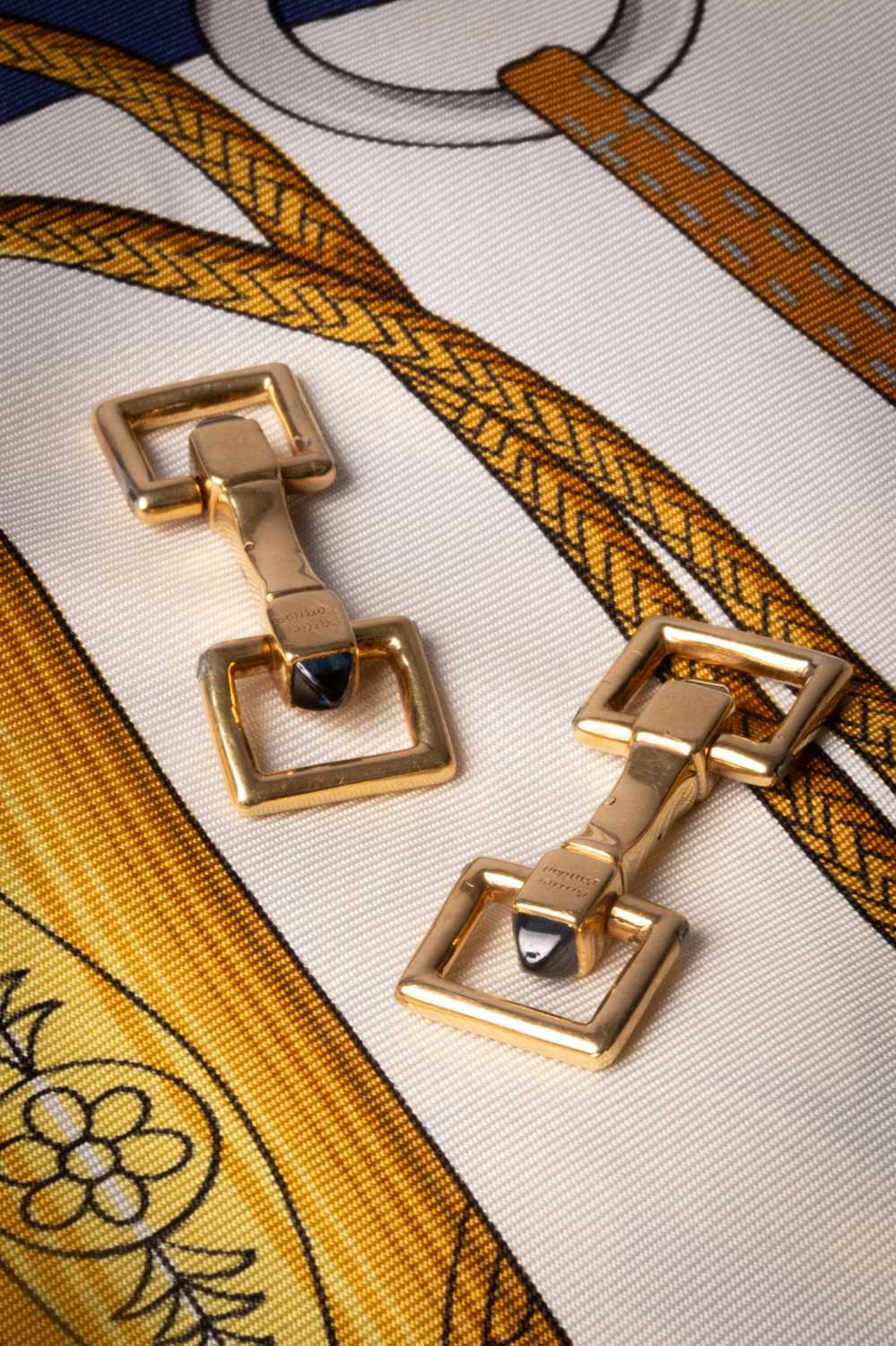 Lot 31 - A pair of Cartier yellow metal and sapphire cufflinks