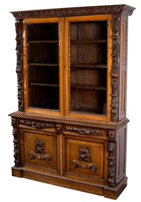 Lot 832 - A carved oak bookcase with maskhead, fruit and...