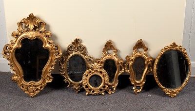 Lot 865 - A gilt framed wall mirror of cartouche shape,...