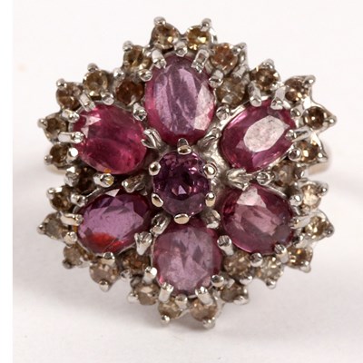 Lot 64 - A ruby and diamond cluster ring, the central...