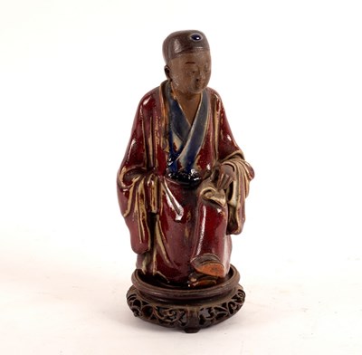 Lot 246 - A Chinese stoneware figure of a seated scholar,...