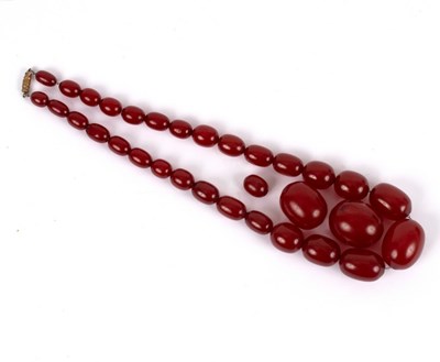 Lot 182 - A single row of graduated cherry amber beads,...