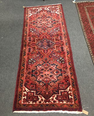 Lot 691 - A Heriz rug, the red ground with three...