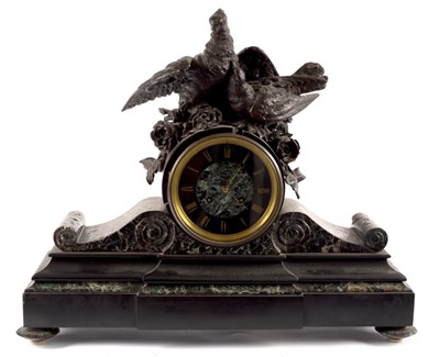 Lot 1015 - A black slate mounted clock with bird surmount,...