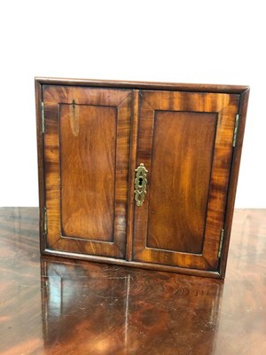 Lot 1075 - A George III mahogany cabinet enclosed by a...