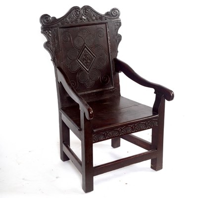 Lot 1076 - A carved oak panel back armchair incorporating...