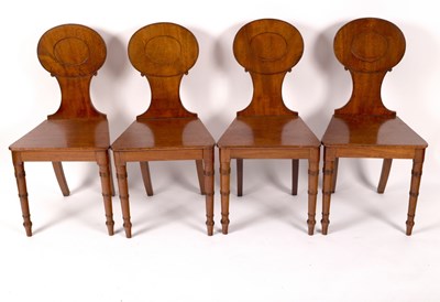 Lot 1199 - A set of four mahogany Regency oak hall chairs