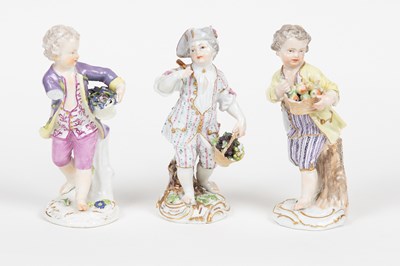 Lot 585 - Three Meissen figures of boys, each with a...