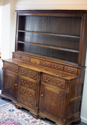 Lot 555 - A Georgian oak Welsh dresser, the rack above...