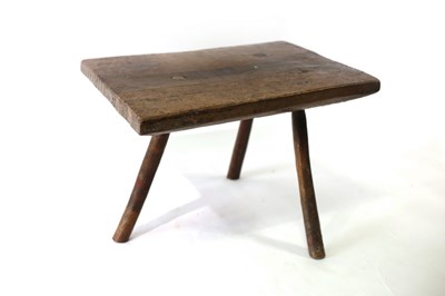 Lot 661 - A primitive three-legged stool/table, the top...