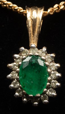 Lot 9 - An emerald and diamond cluster pendant on a...