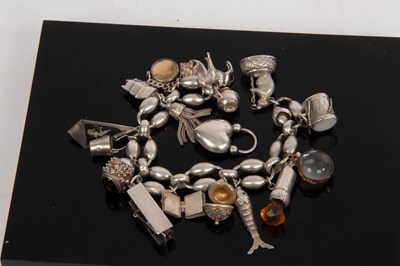 Lot 20 - A white metal charm bracelet, hung with a...
