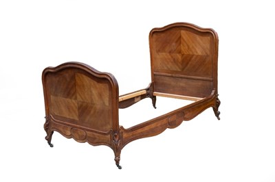 Lot 662 - A French walnut bed with moulded arched head...