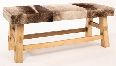 Lot 647 - A hide upholstered stool, 111cm wide