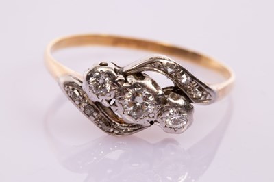 Lot 10 - A three-stone diamond crossover ring, set in...