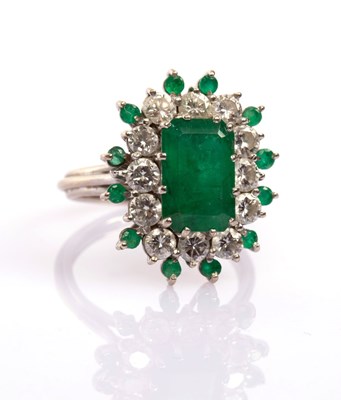 Lot 22 - An emerald and diamond cluster ring, the...