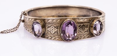 Lot 31 - A silver gilt and amethyst hinged bangle, the...
