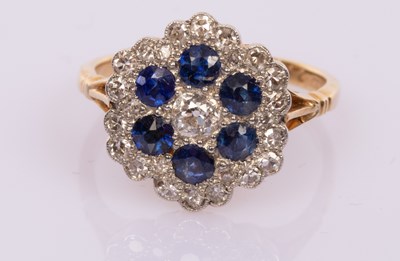 Lot 48 - A diamond and sapphire flowerhead cluster ring,...