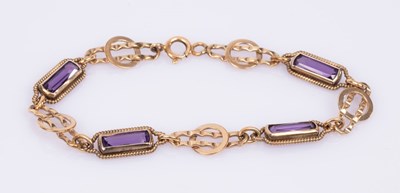 Lot 61 - A hinged bangle set with three peridot in a...