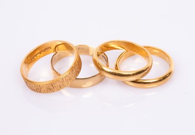 Lot 79 - A textured 22ct yellow gold wedding band,...