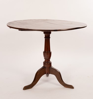 Lot 681 - A George III oak circular tilt-top occasional...