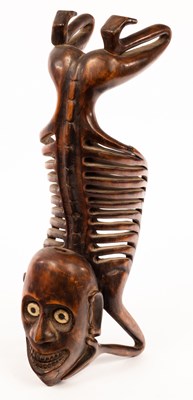 Lot 961 - A tribal carving of a kneeling skeletal figure,...