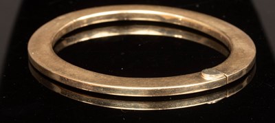 Lot 420 - A 9ct yellow gold hinged bangle of flattened...