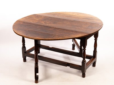 Lot 555 - An oval oak gate leg table, the two-flap top...