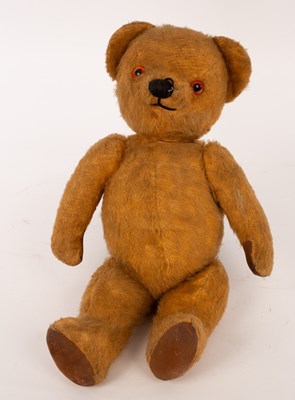 Lot 715 - A teddy bear with glass eyes and swivel joints,...