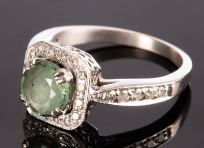 Lot 215 - A green sapphire and diamond cluster ring, the...