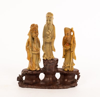 Lot 414 - A Chinese carved soapstone group of three...