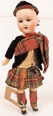 Lot 501 - A bisque head doll in Highland dress,...