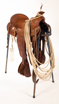 Lot 521 - A Texas roping saddle on stand, with lariat...