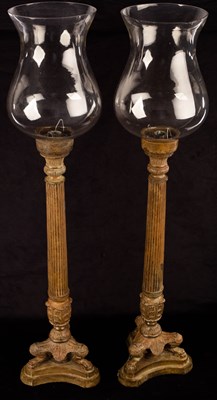 Lot 720 - A pair of patinated metal candle holders of...