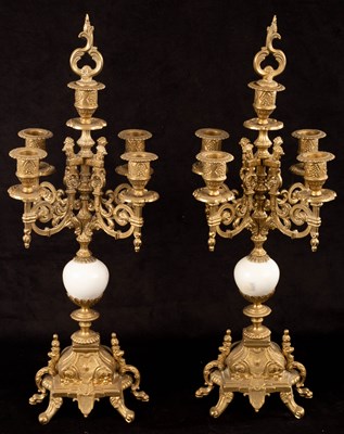 Lot 747 - A pair of four-branch brass candelabra, the...