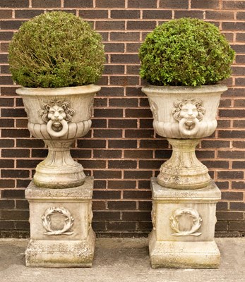 Lot 783 - A pair of composition stone urns with lion...